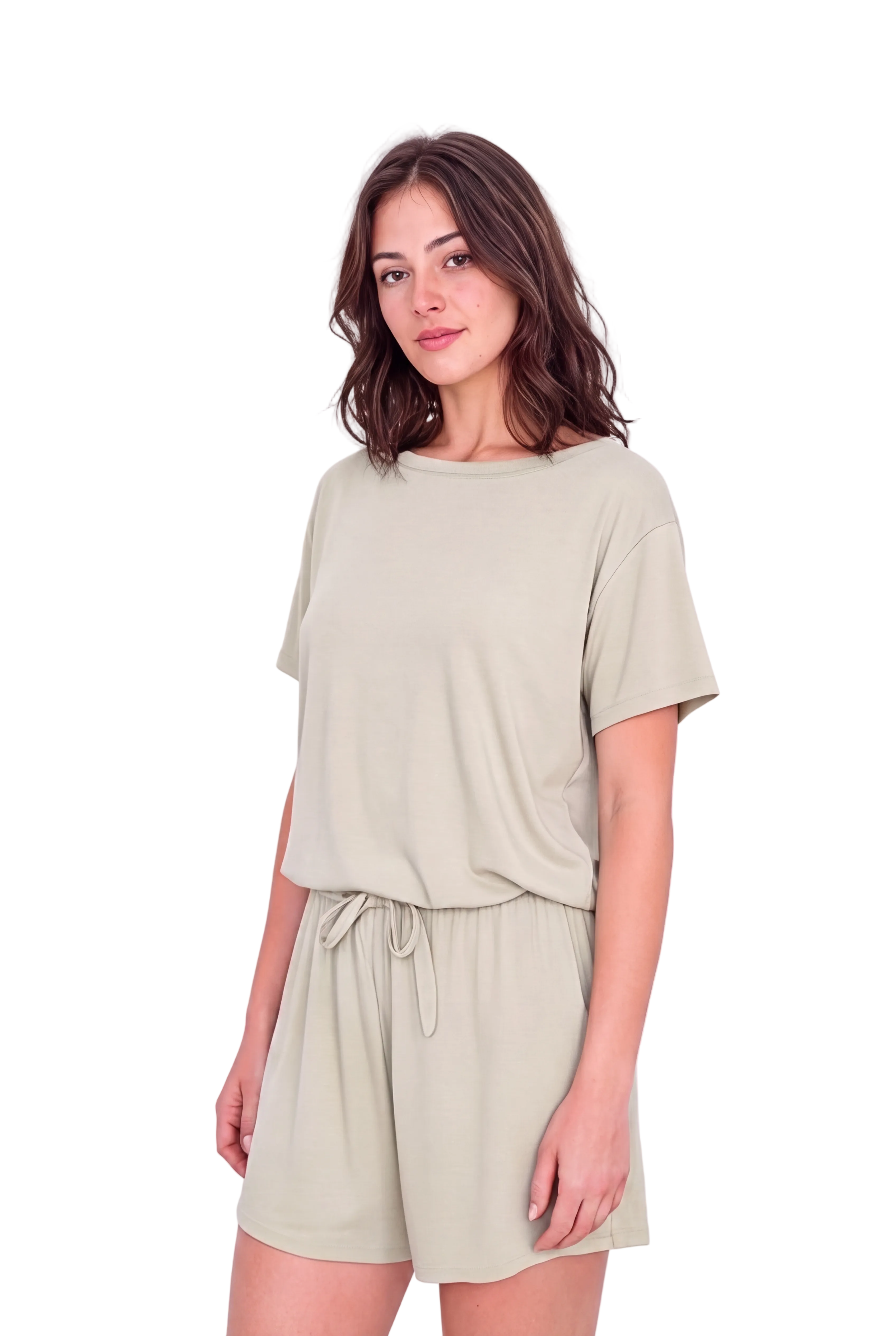 A woman modeling a light sage green short-sleeve t-shirt and matching drawstring shorts set against a plain light background.